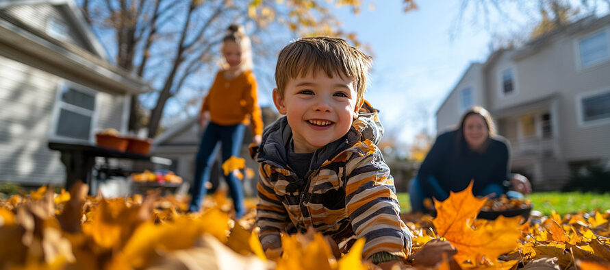 Enfant jouant dans les feuilles d'automne avec sa famille